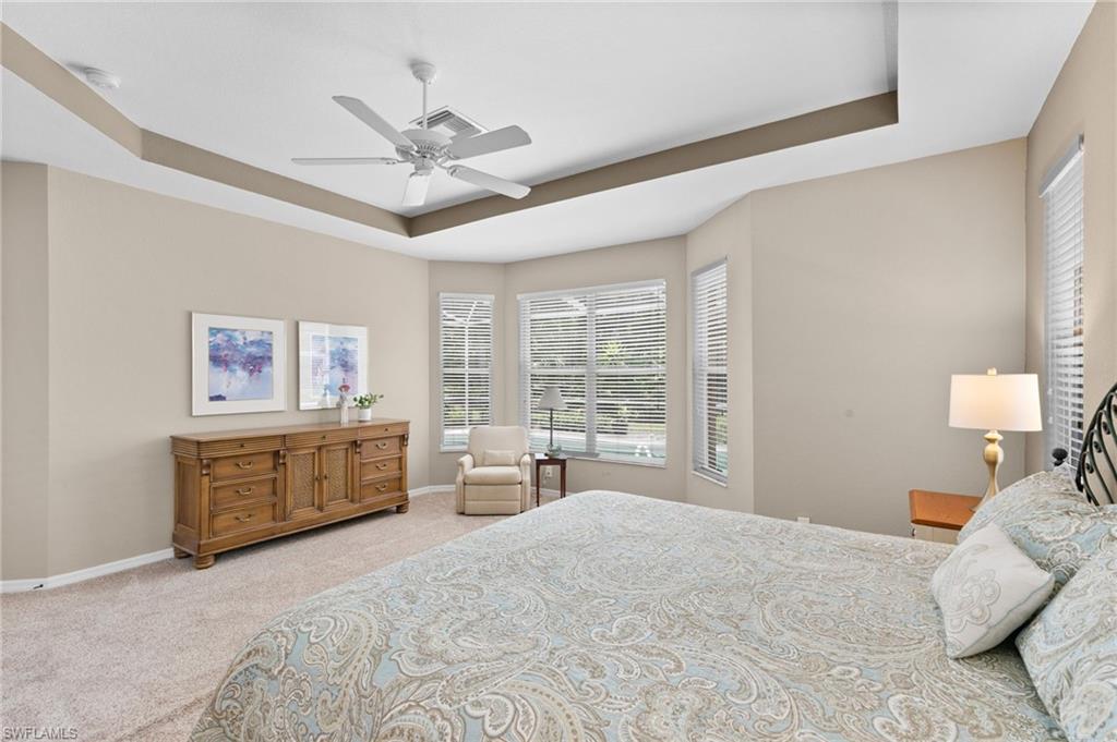 1717 Winding Oaks Way Naples, FL 34109 - Photo 18 of 35 Bedroom with ceiling fan, a raised ceiling, and carpet flooring