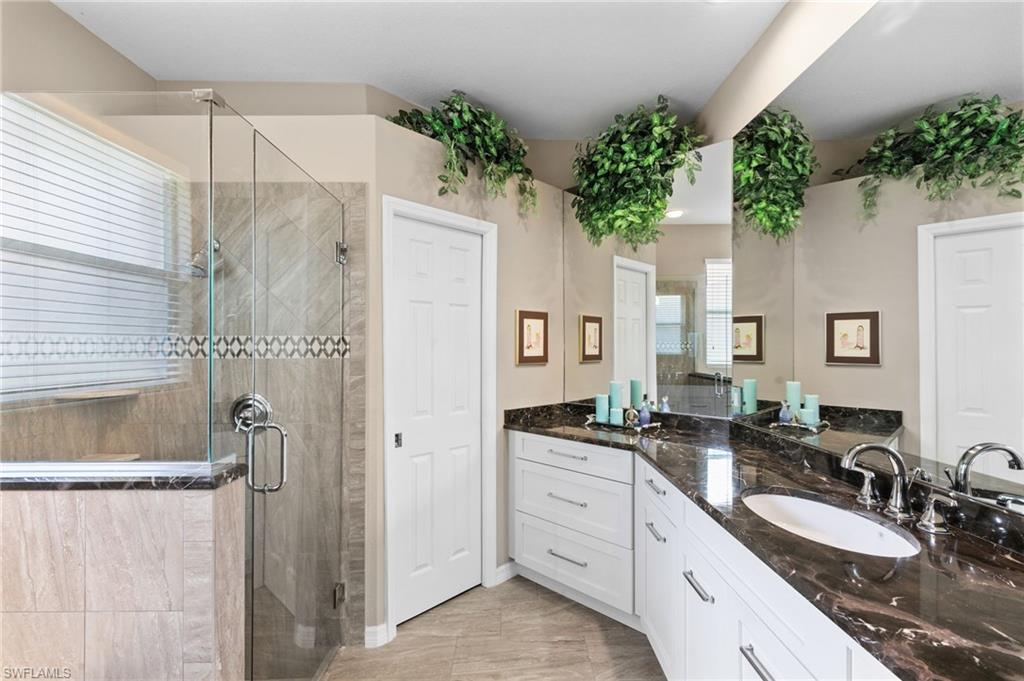 1717 Winding Oaks Way Naples, FL 34109 - Photo 19 of 35 Bathroom featuring dual vanity, a shower with door, and tile flooring