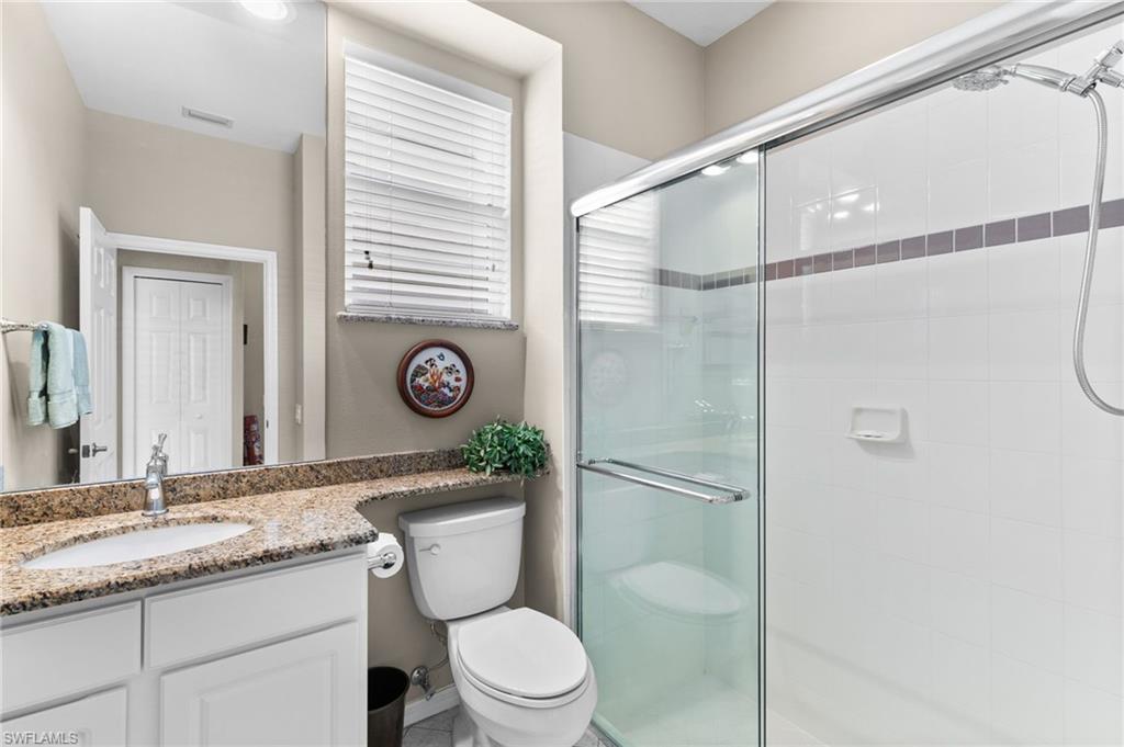 1717 Winding Oaks Way Naples, FL 34109 - Photo 23 of 35 Bathroom with a shower with door, vanity, and toilet