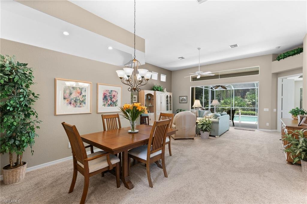 1717 Winding Oaks Way Naples, FL 34109 - Photo 7 of 35 Dining space featuring ceiling fan with notable chandelier and carpet floors