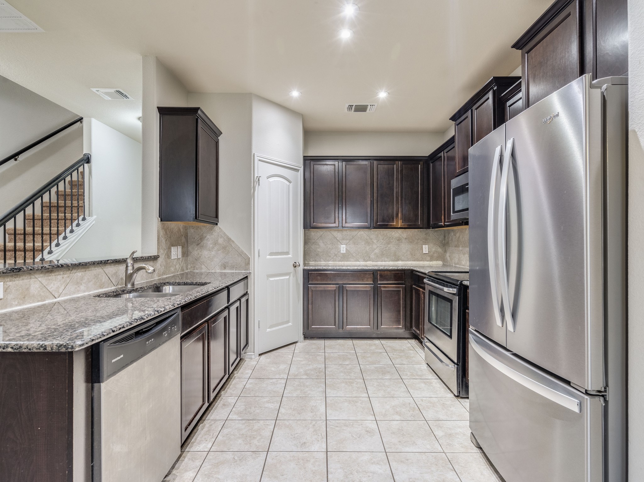 213 Ammonite Lane Jarrell, TX 76537 - Photo 8 of 34 a kitchen with granite countertop a refrigerator and a sink