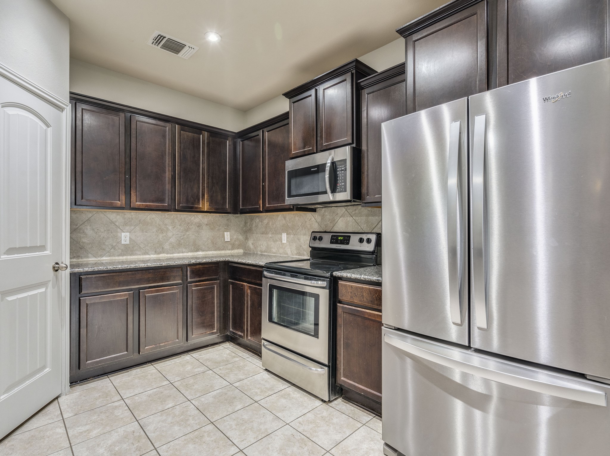 213 Ammonite Lane Jarrell, TX 76537 - Photo 9 of 34 a kitchen with stainless steel appliances granite countertop a refrigerator stove and sink