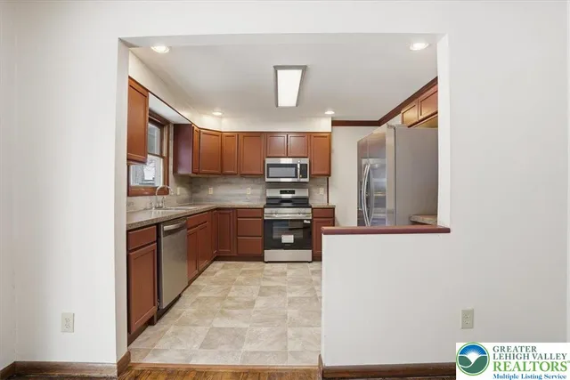 a kitchen with stainless steel appliances granite countertop a refrigerator sink and stove