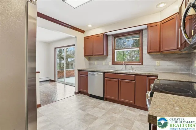 a view of a refrigerator in kitchen and an empty room