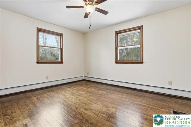 a view of an empty room with wooden floor and closet