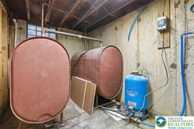 a backyard of a house with table and chairs under an large tree