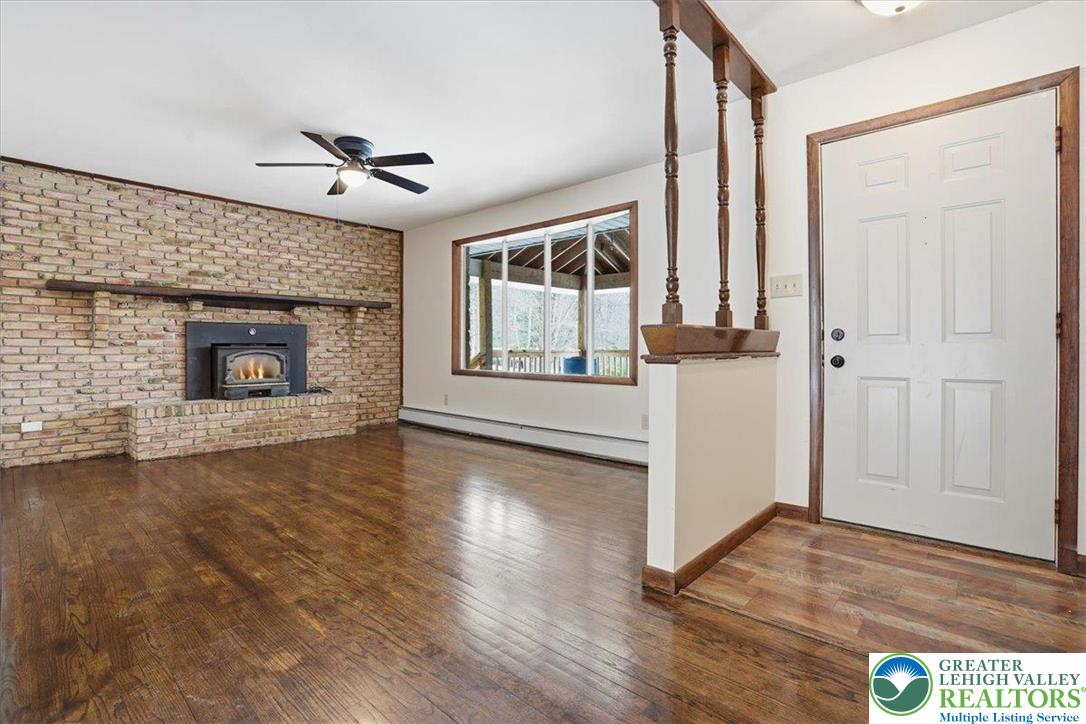 401 Highland Hill Road Jim Thorpe, PA 18235 - Photo 10 of 71 an empty room with wooden floor fireplace and windows