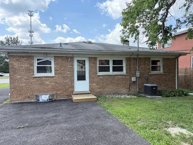 a view of a house with a yard and a large tree