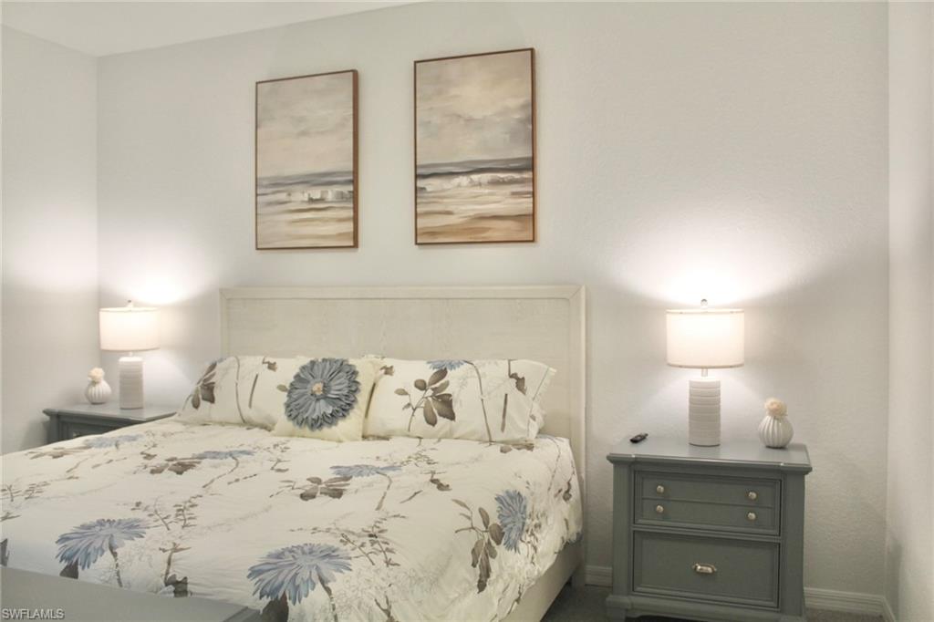 15405 Grn Acrs Avenue, Unit 2341 Babcock Ranch, FL 33982 - Photo 11 of 28 a bedroom with a bed and a lamp on dresser