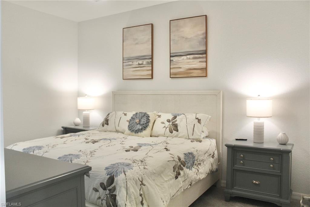 15405 Grn Acrs Avenue, Unit 2341 Babcock Ranch, FL 33982 - Photo 13 of 28 a bedroom with a bed and a lamp on dresser