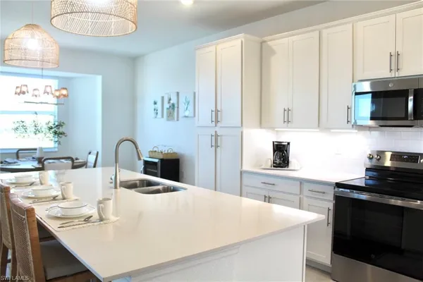 a kitchen with kitchen island granite countertop a sink a stove and cabinets