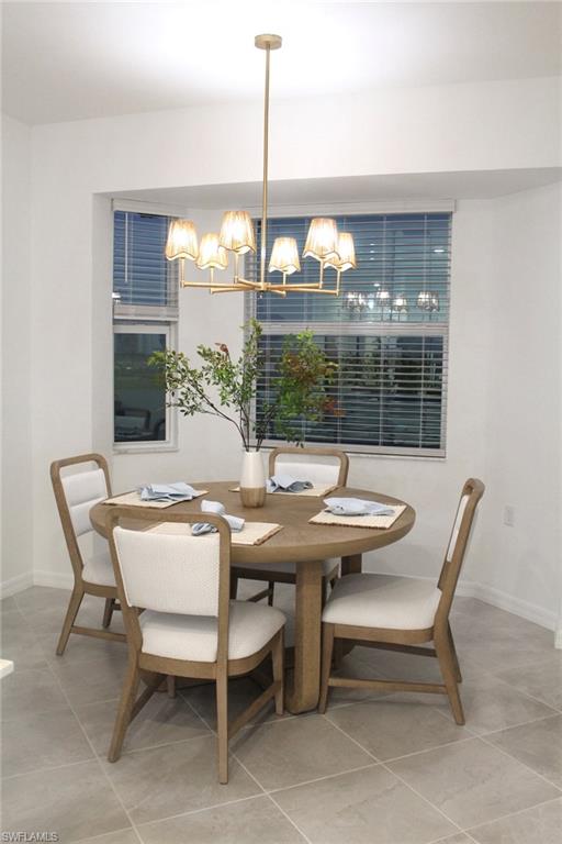15405 Grn Acrs Avenue, Unit 2341 Babcock Ranch, FL 33982 - Photo 9 of 28 a view of a dining room with furniture wooden floor and chandelier