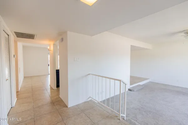 an empty room with fan and entrance