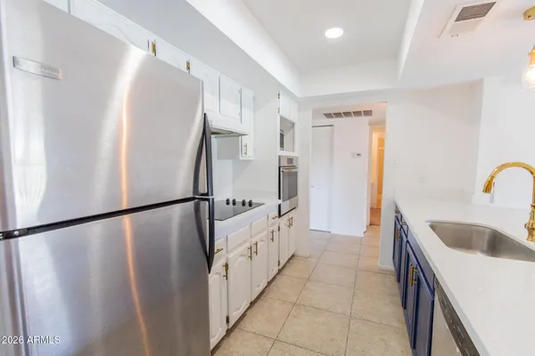 a kitchen with stainless steel appliances granite countertop a refrigerator stove and sink