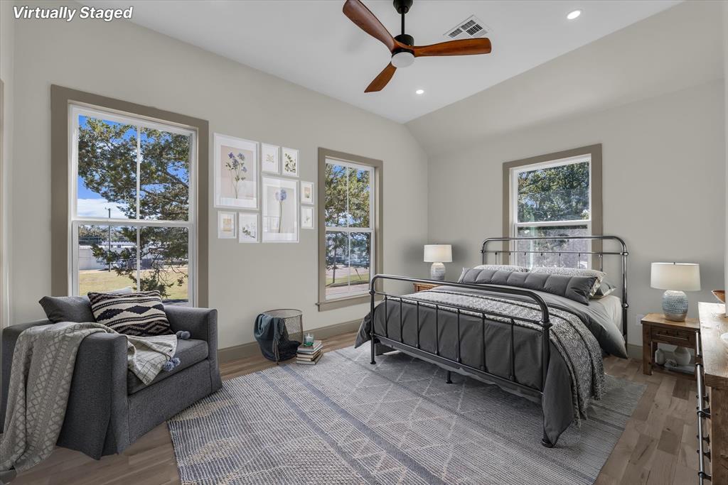 718 Tyler Street Waco, TX 76704 - Photo 19 of 39 a spacious bedroom with a bed a couch and a window