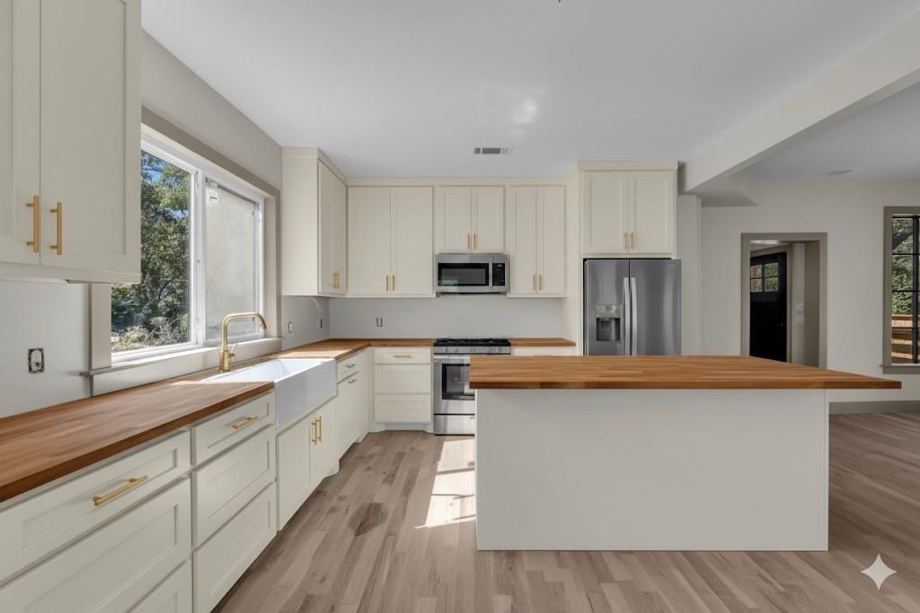 718 Tyler Street Waco, TX 76704 - Photo 8 of 39 a kitchen with stainless steel appliances granite countertop a stove a sink and a refrigerator