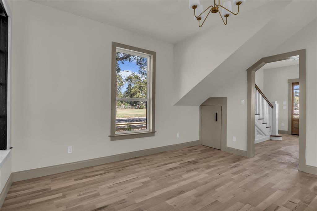 718 Tyler Street Waco, TX 76704 - Photo 10 of 39 a view of an empty room with a window and wooden floor