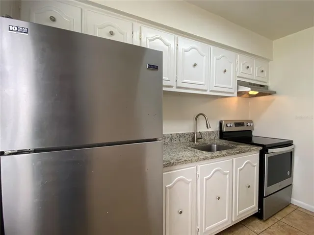 a kitchen with granite countertop a sink and cabinets