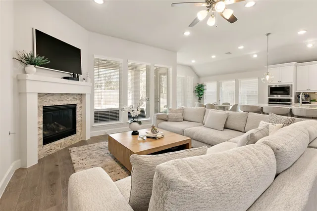 a living room with furniture a fireplace and a flat screen tv