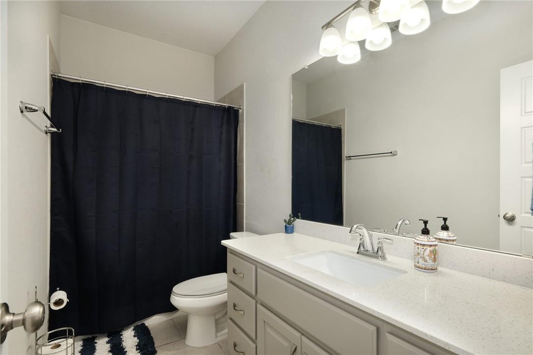 229 Bonnet Boulevard Georgetown, TX 78628 - Photo 15 of 20 Bathroom with curtained shower, vanity, and light tile patterned flooring