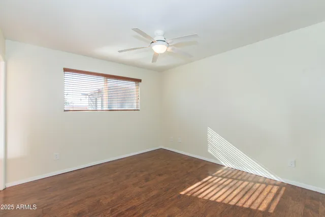 a view of a hallway with wooden floor and a bathroom