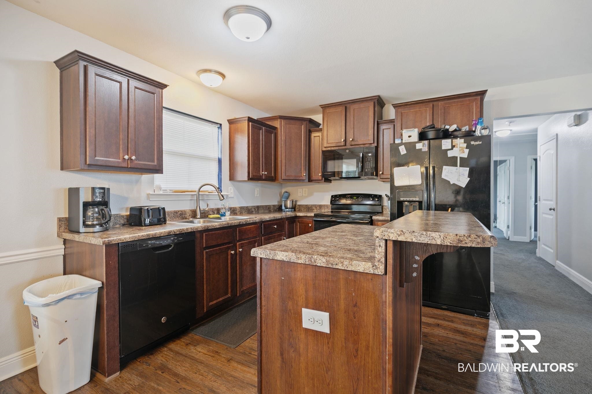 15573 Talus Court Foley, AL 36535 - Photo 15 of 50 Kitchen featuring dark wood-type flooring, black appliances, and a kitchen island