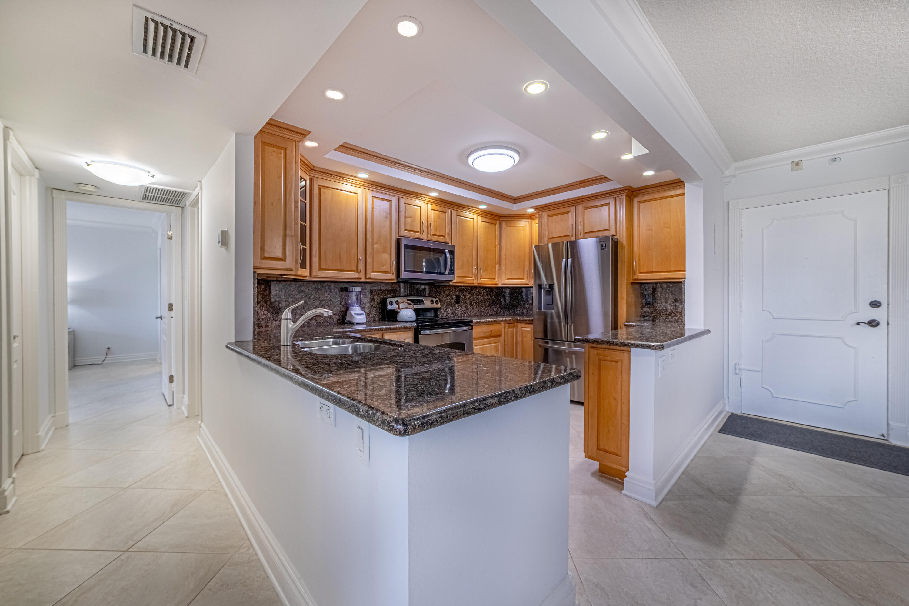 405 North Ocean Boulevard, Unit 507 Pompano Beach, FL 33062 - Photo 14 of 38 a kitchen with stainless steel appliances granite countertop a stove a sink and a refrigerator