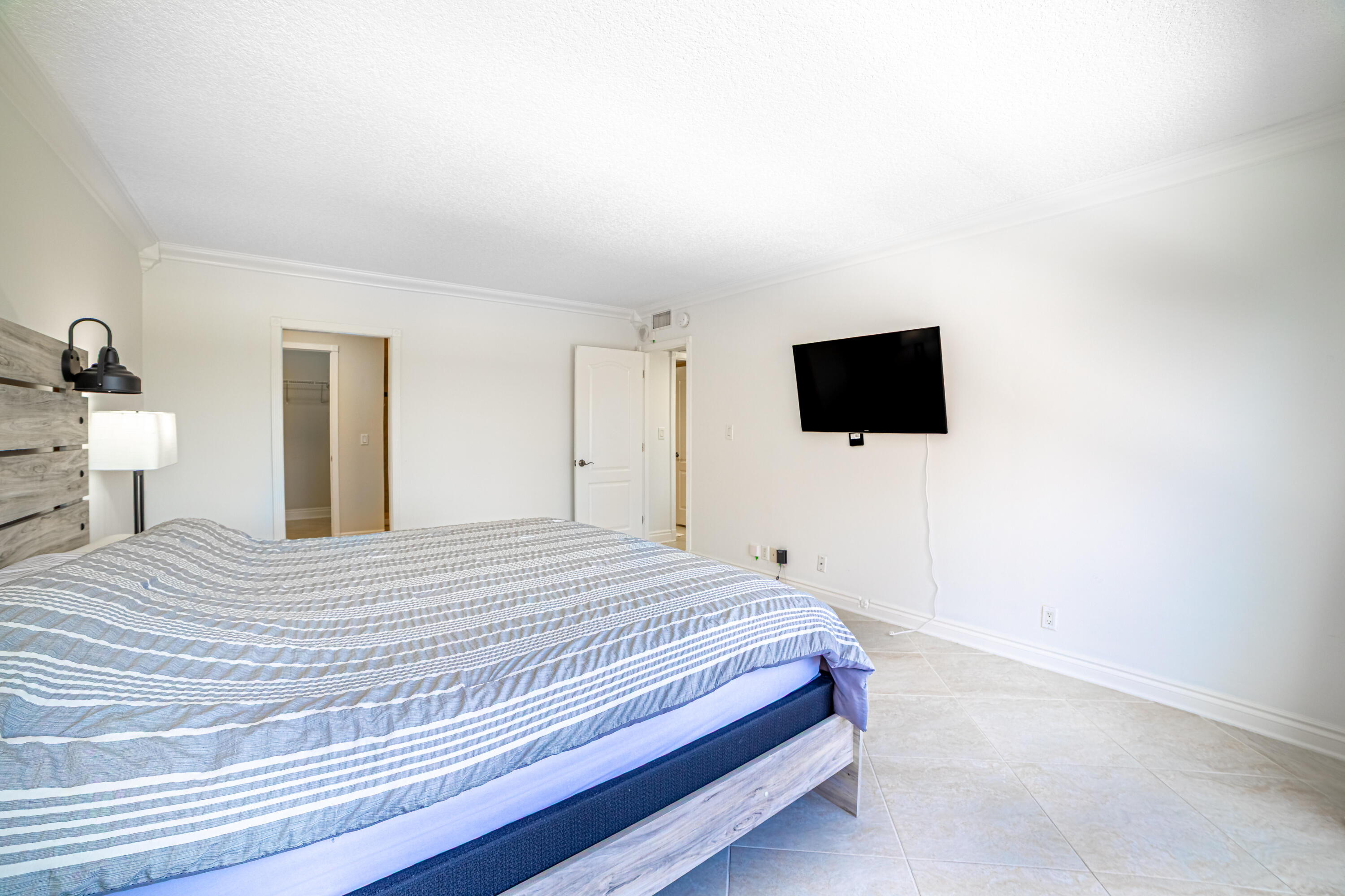 405 North Ocean Boulevard, Unit 507 Pompano Beach, FL 33062 - Photo 17 of 38 a bedroom with a bed and a flat screen tv