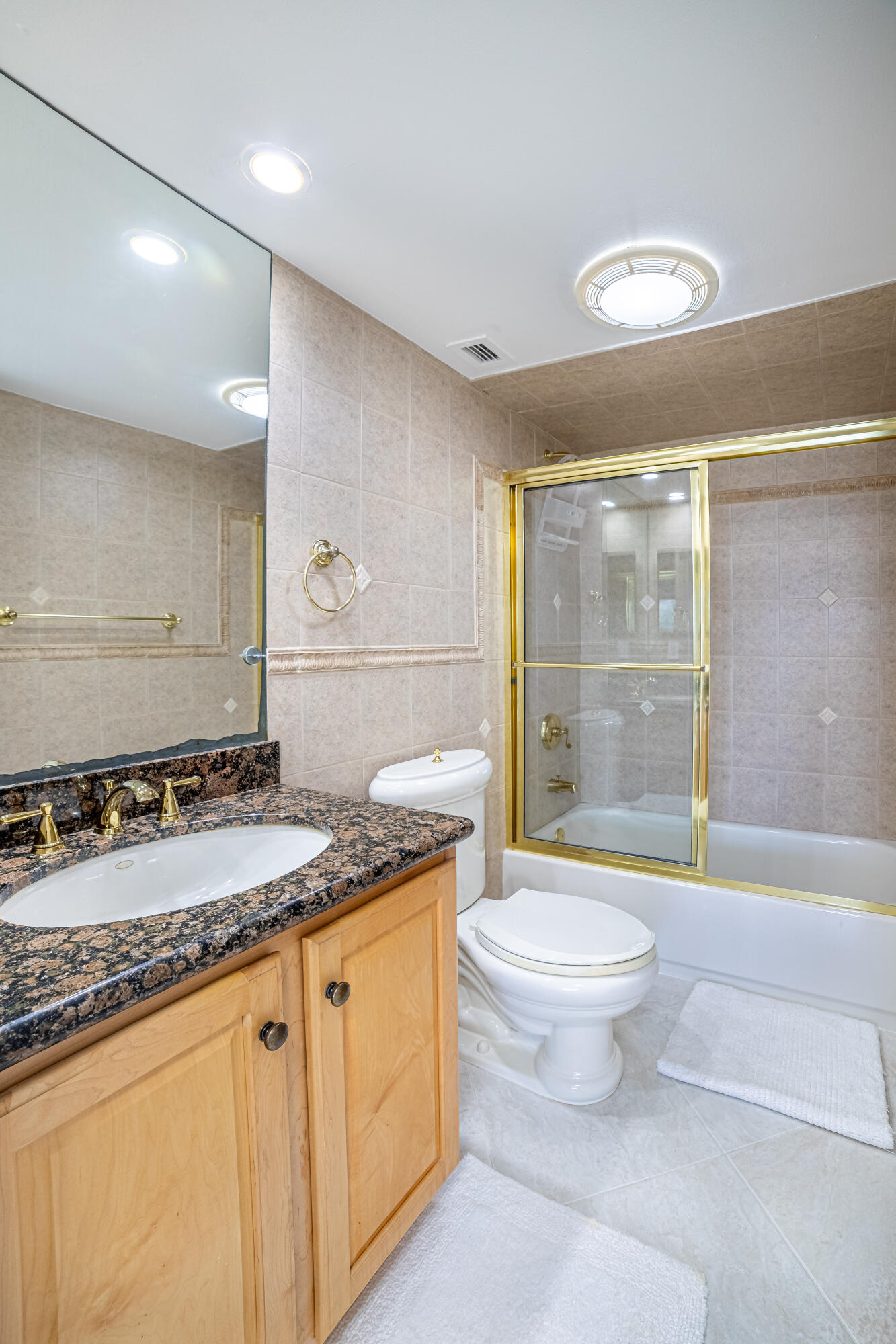 405 North Ocean Boulevard, Unit 507 Pompano Beach, FL 33062 - Photo 18 of 38 a bathroom with a granite countertop sink a toilet a mirror and a shower