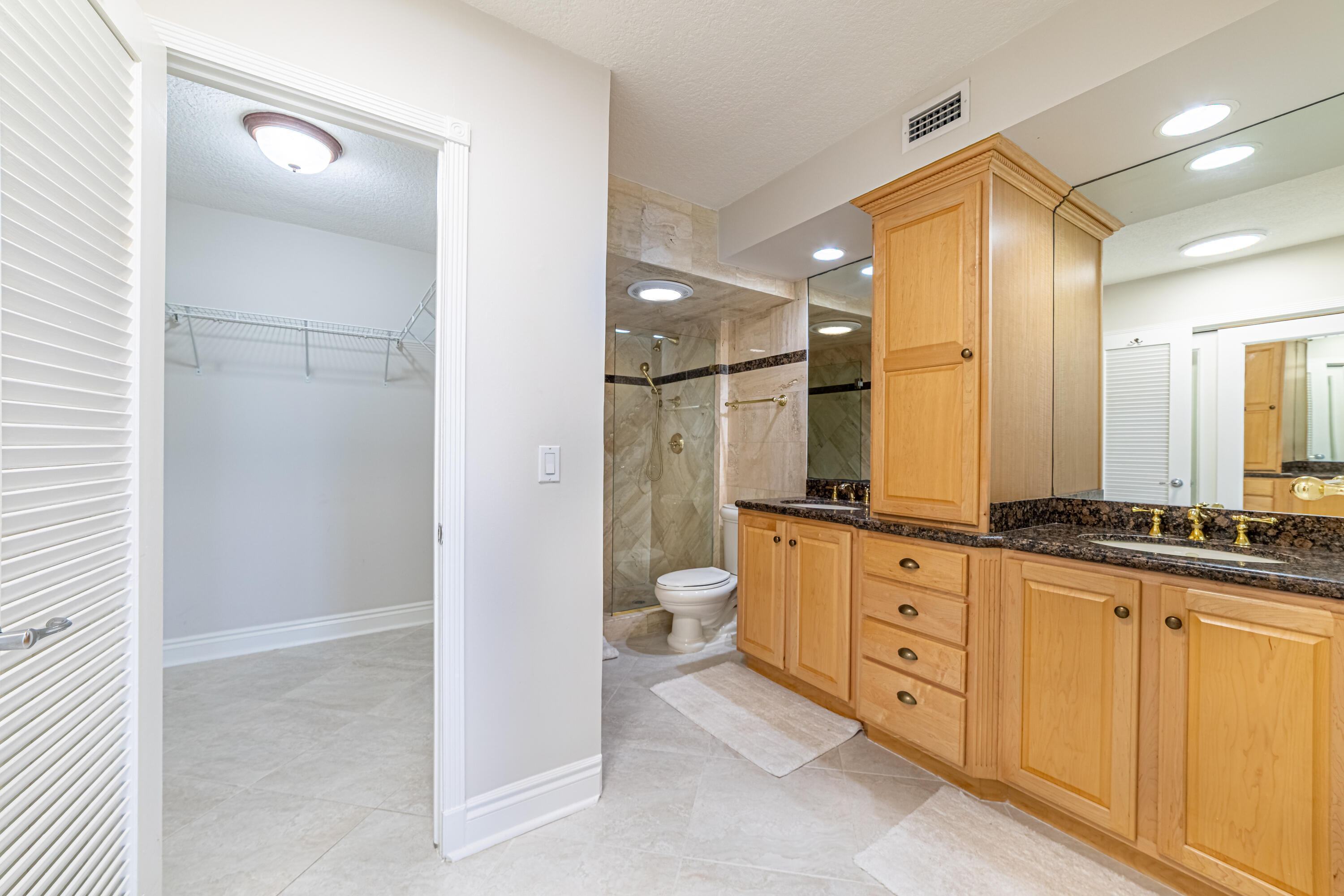 405 North Ocean Boulevard, Unit 507 Pompano Beach, FL 33062 - Photo 19 of 38 a bathroom with a granite countertop sink a toilet a mirror and shower