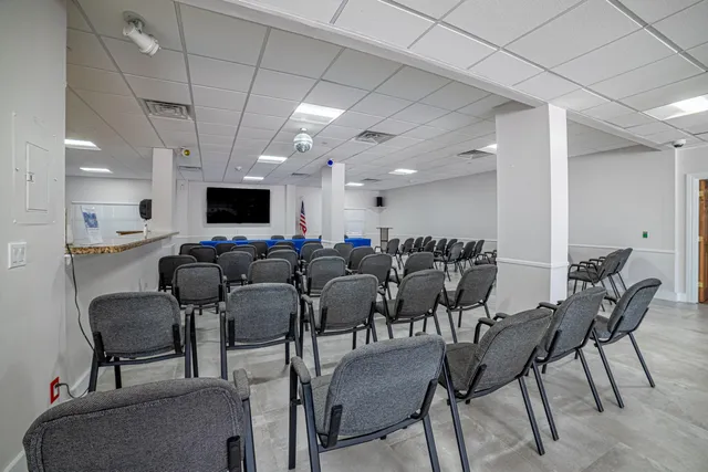 a dining room with furniture water view and a floor to ceiling window