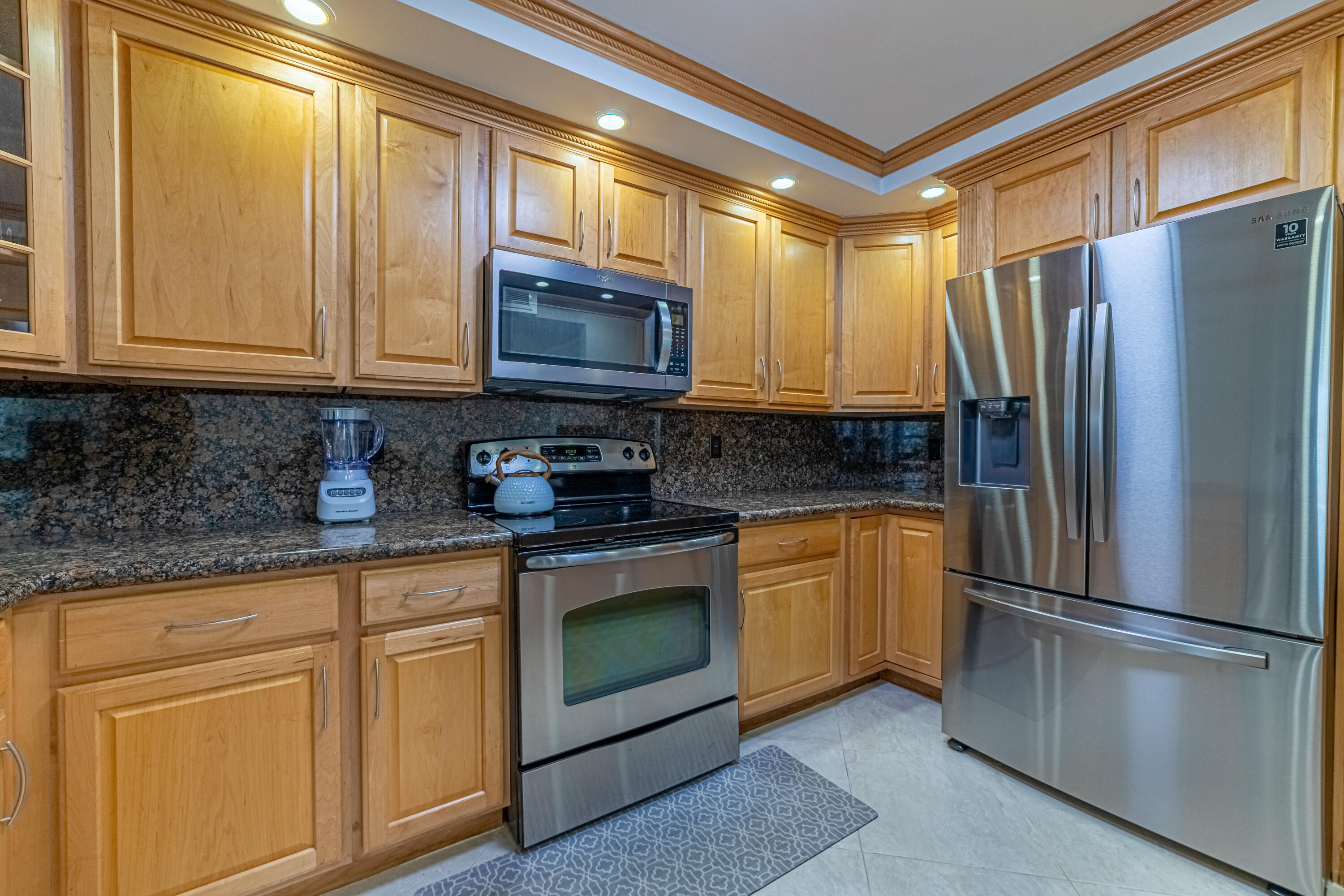 405 North Ocean Boulevard, Unit 507 Pompano Beach, FL 33062 - Photo 3 of 38 a kitchen with stainless steel appliances granite countertop a refrigerator a stove a sink and a microwave