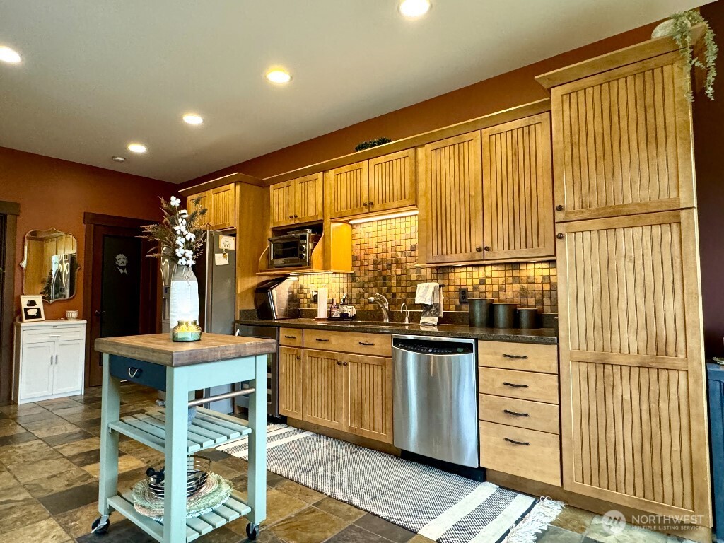 21713 45th Avenue Southeast Bothell, WA 98021 - Photo 31 of 40 a kitchen with stainless steel appliances kitchen island granite countertop a sink and cabinets