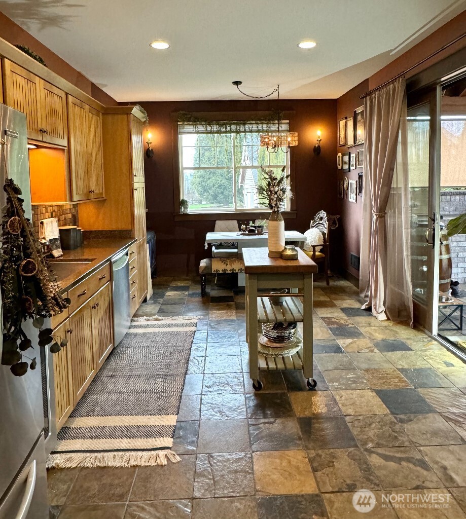 21713 45th Avenue Southeast Bothell, WA 98021 - Photo 36 of 40 a kitchen with stainless steel appliances kitchen island granite countertop a refrigerator and a stove