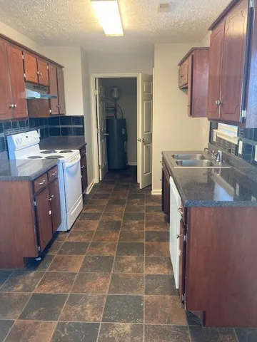 a kitchen with a sink stove and cabinets