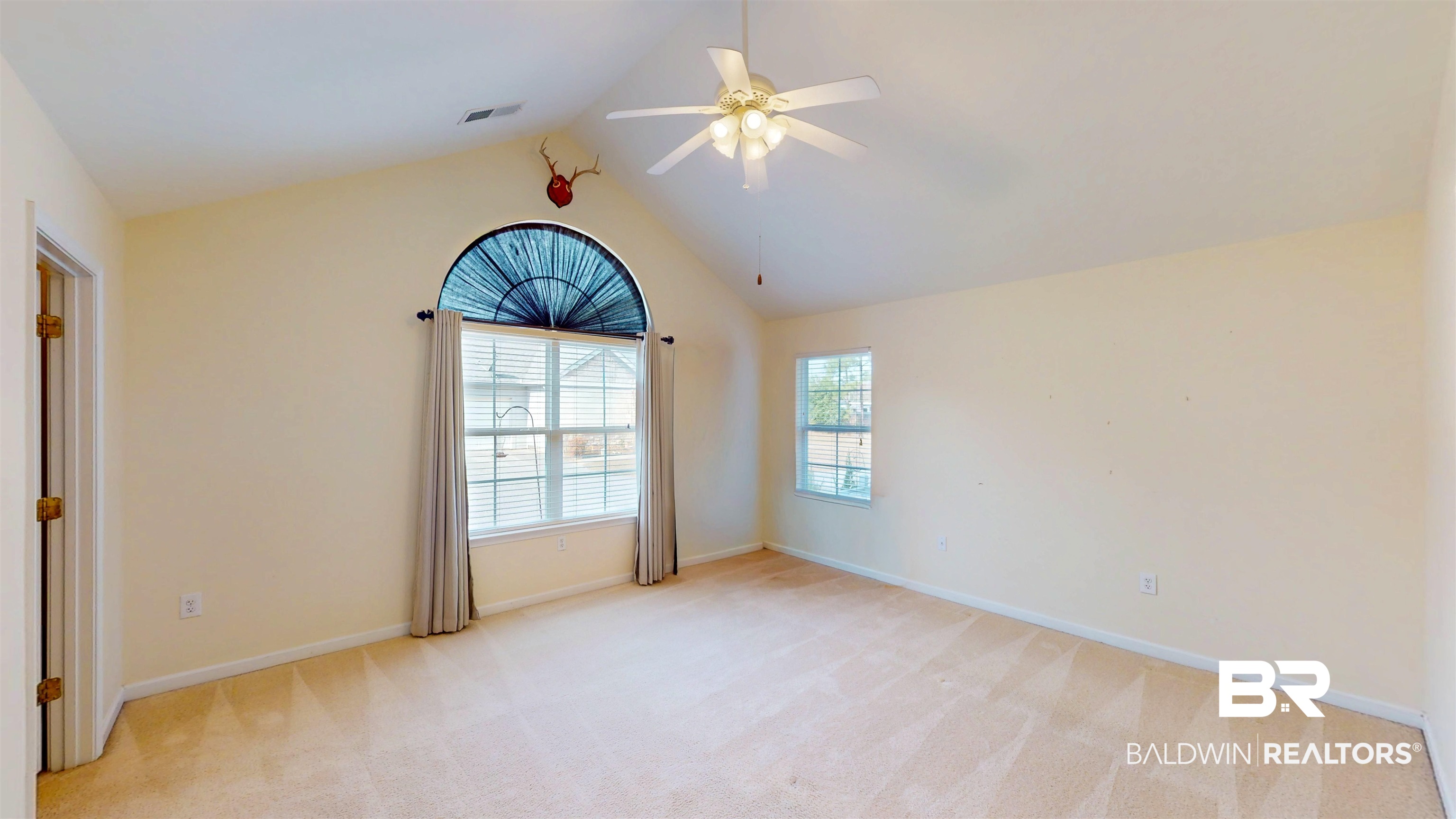 303 Wyld Palms Drive, Unit 303 Foley, AL 36535 - Photo 23 of 36 Empty room featuring ceiling fan, vaulted ceiling, and light colored carpet