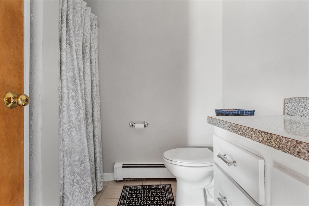 11 Clearview Road Stoneham, MA 02180 - Photo 33 of 42 a bathroom with a granite countertop toilet a sink and a shower