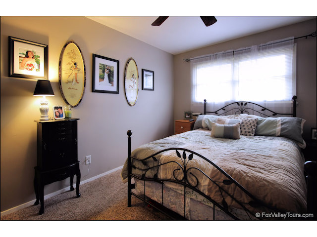 56 Sheffield Road Montgomery, IL 60538 - Photo 12 of 18 a bedroom with a bed a mirror and a large window