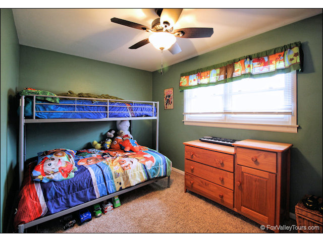 56 Sheffield Road Montgomery, IL 60538 - Photo 16 of 18 a bedroom with a bed and a chandelier