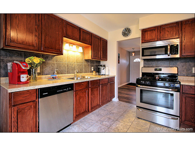 56 Sheffield Road Montgomery, IL 60538 - Photo 7 of 18 a kitchen with stainless steel appliances granite countertop a sink stove and microwave