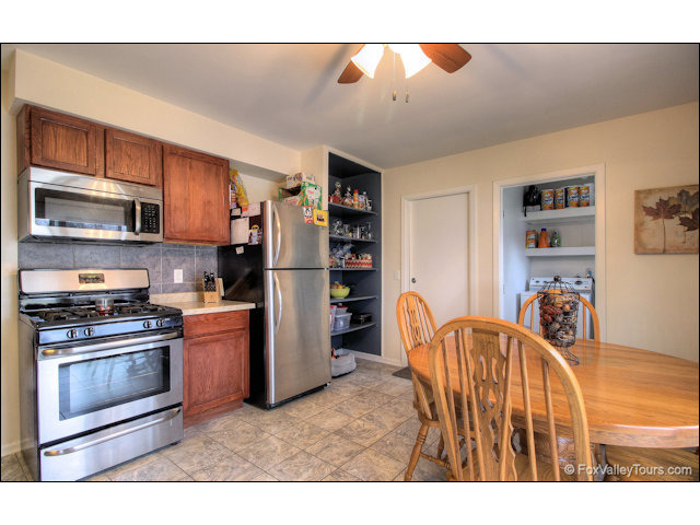 56 Sheffield Road Montgomery, IL 60538 - Photo 8 of 18 a kitchen with stainless steel appliances granite countertop a refrigerator and a stove top oven