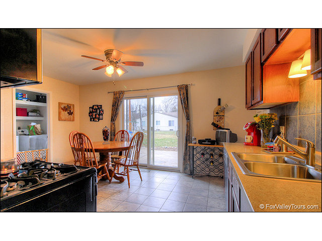 56 Sheffield Road Montgomery, IL 60538 - Photo 10 of 18 a kitchen with furniture a stove and a flat screen tv