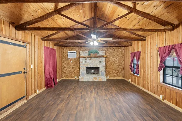 a view of an empty room with a fireplace and wooden floor