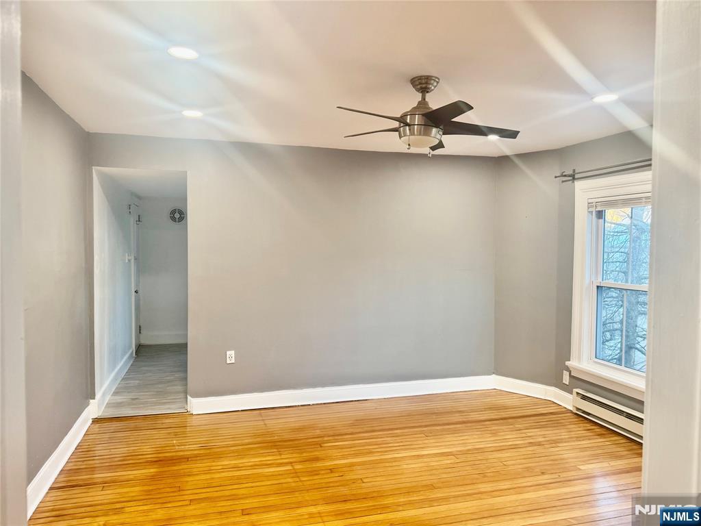 154 Clinton Place, Unit 2 Hackensack, NJ 07601 - Photo 4 of 11 a view of an empty room with window and wooden floor