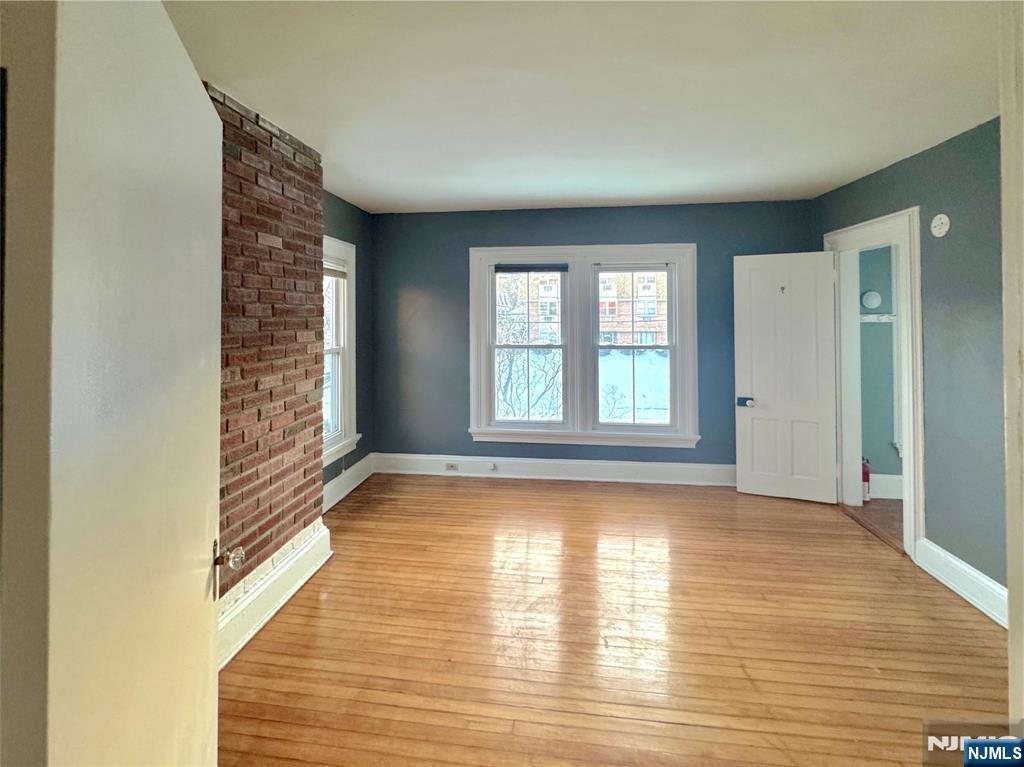 154 Clinton Place, Unit 2 Hackensack, NJ 07601 - Photo 6 of 11 a view of an empty room with window and wooden floor