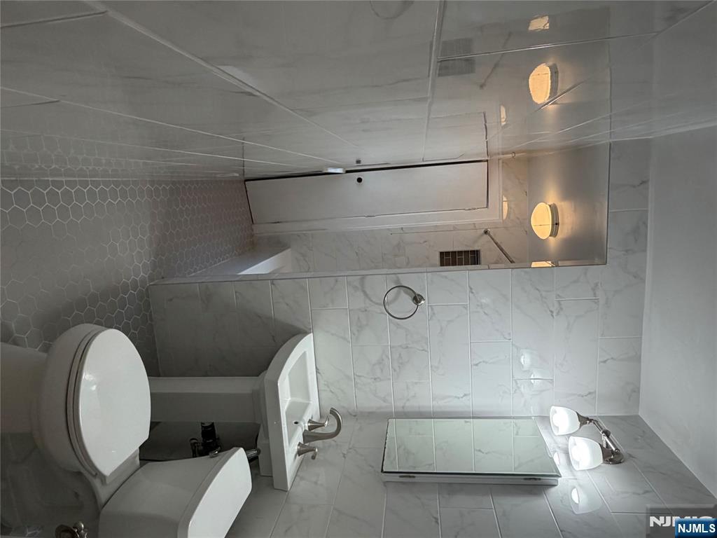 154 Clinton Place, Unit 2 Hackensack, NJ 07601 - Photo 10 of 11 a bathroom with a toilet a sink and shower