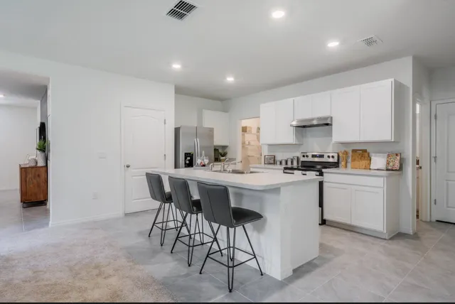 a kitchen with a sink and chairs