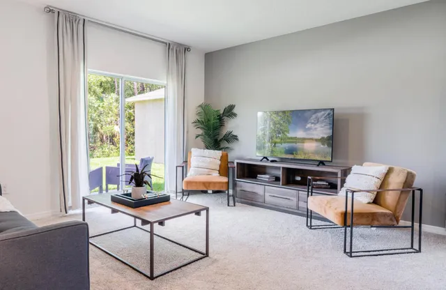 a living room with furniture and a potted plant