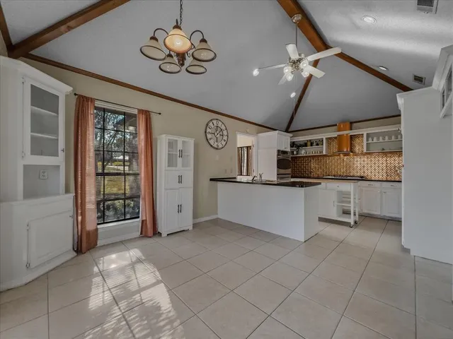 a living room with furniture a flat screen tv and kitchen view