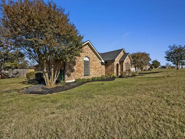 a view of a house with backyard and trees